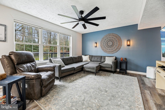 living room with ceiling fan, dark hardwood / wood-style flooring, and a textured ceiling