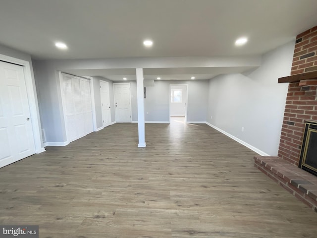 basement with a fireplace and dark hardwood / wood-style floors