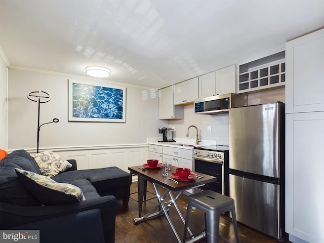 kitchen featuring dark wood-type flooring, white cabinets, stainless steel appliances, and sink