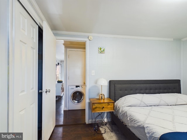 bedroom featuring wood walls, ornamental molding, dark hardwood / wood-style floors, and washer / dryer