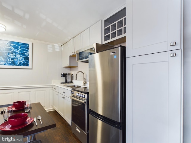 kitchen with stainless steel appliances, white cabinetry, dark wood-type flooring, and sink