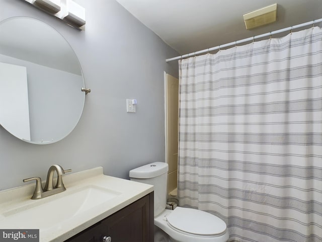 bathroom with a shower with shower curtain, vanity, and toilet