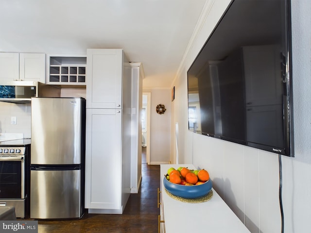 kitchen featuring white cabinetry, dark wood-type flooring, stainless steel appliances, and ornamental molding