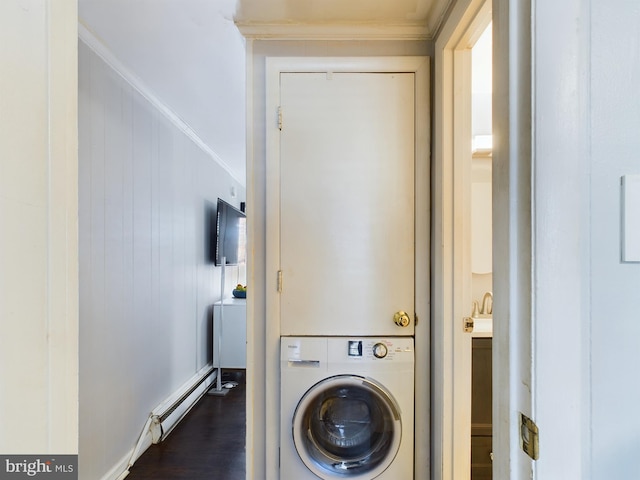 washroom with a baseboard heating unit, crown molding, stacked washer and clothes dryer, dark hardwood / wood-style floors, and wood walls