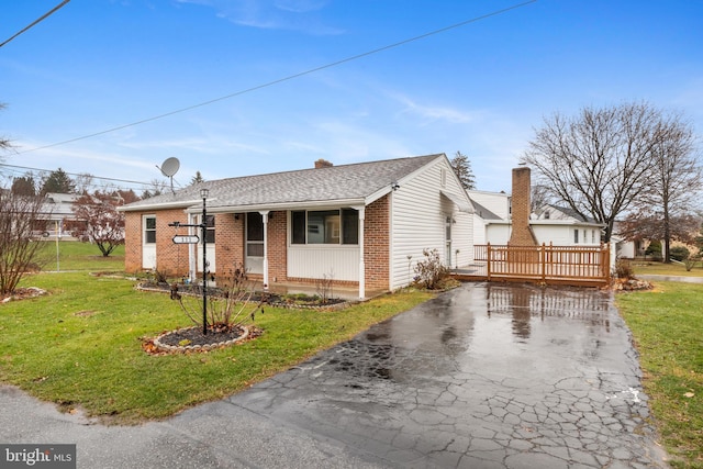 view of front of home with a wooden deck and a front lawn