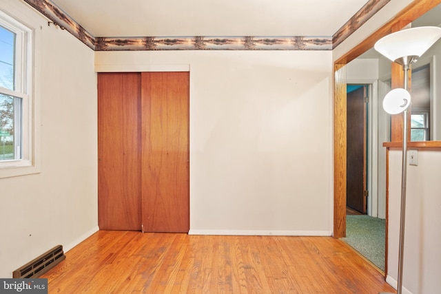 unfurnished bedroom with light wood-type flooring and a closet