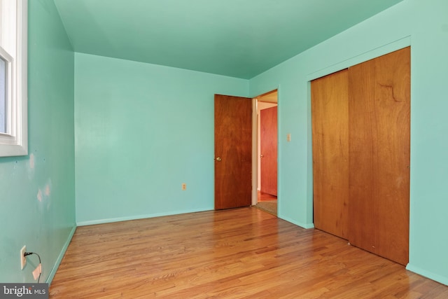 unfurnished bedroom featuring light hardwood / wood-style floors and a closet