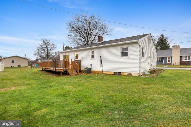 rear view of property with a lawn, a deck, and central air condition unit