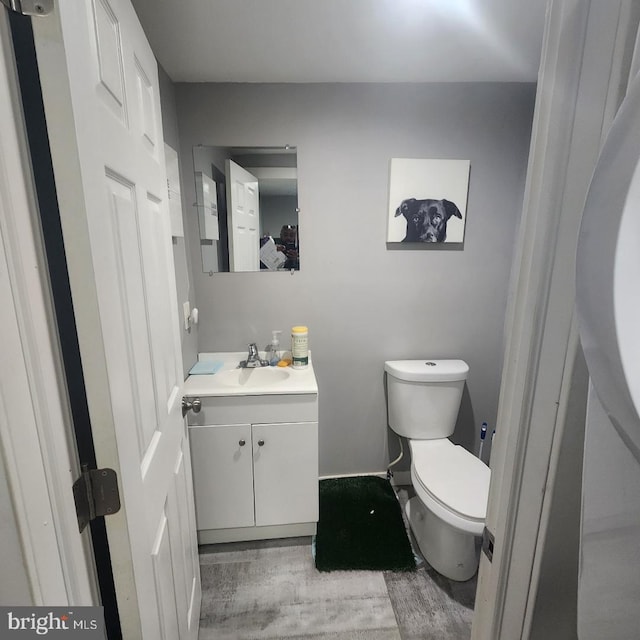 bathroom featuring hardwood / wood-style flooring, vanity, and toilet