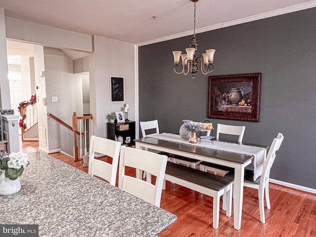 dining area featuring hardwood / wood-style floors, a notable chandelier, and ornamental molding