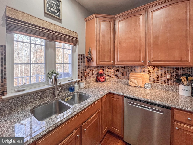 kitchen featuring dishwasher, light stone counters, plenty of natural light, and sink