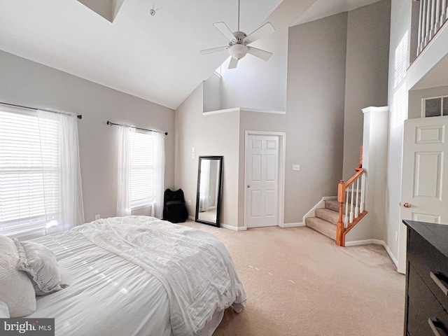 carpeted bedroom featuring high vaulted ceiling, multiple windows, and ceiling fan