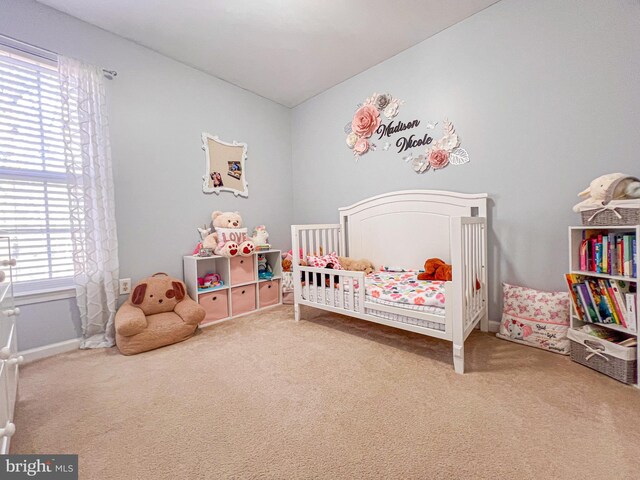 bedroom featuring carpet flooring and a nursery area