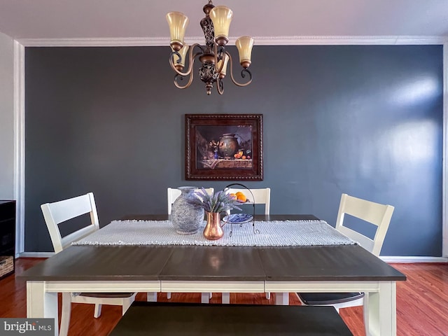 dining area with a chandelier, hardwood / wood-style flooring, and crown molding