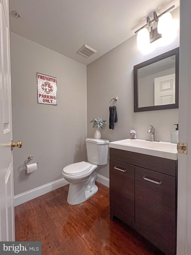 bathroom featuring hardwood / wood-style flooring, vanity, and toilet