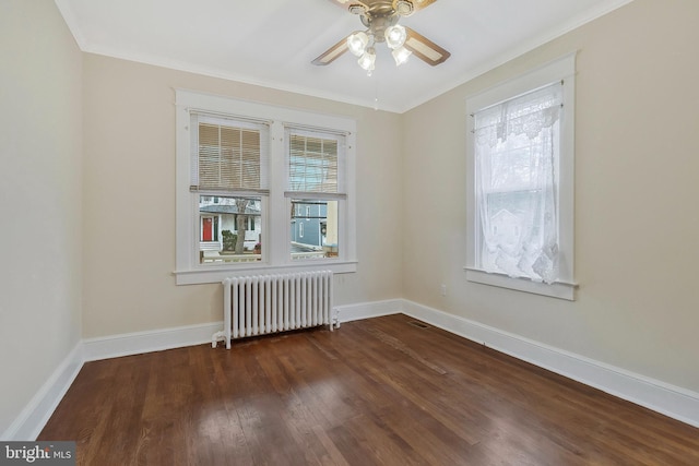 empty room featuring dark hardwood / wood-style flooring, ceiling fan, radiator heating unit, and a healthy amount of sunlight