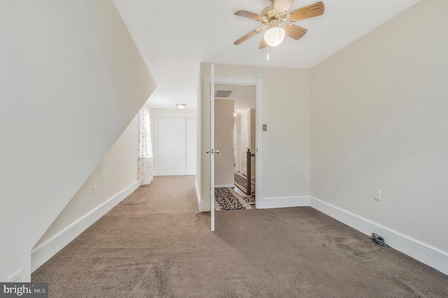 bonus room with ceiling fan and carpet