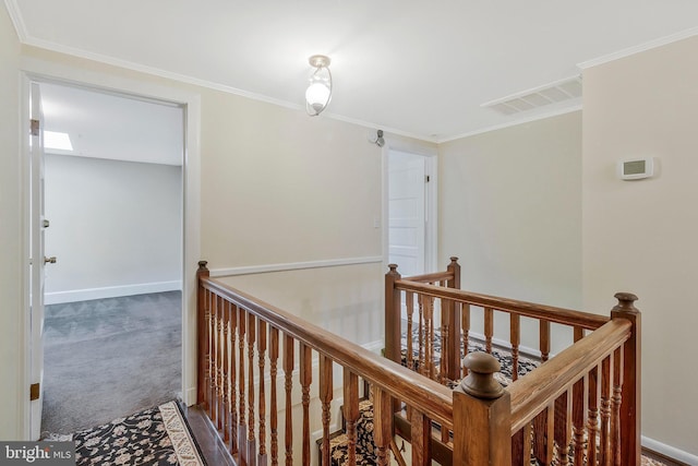 hallway with ornamental molding and carpet flooring