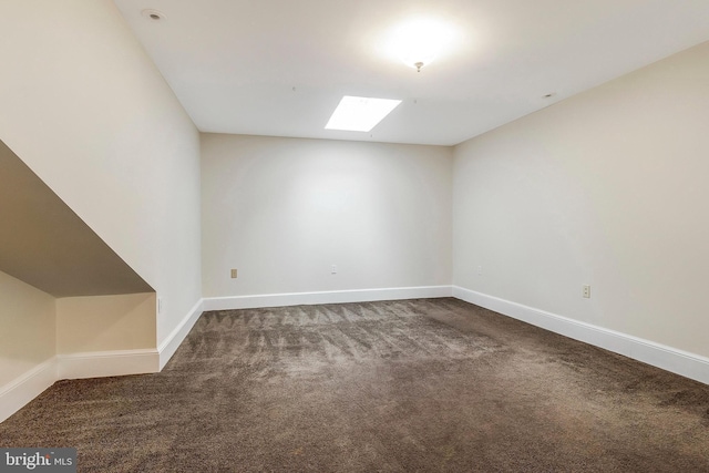 carpeted empty room featuring a skylight