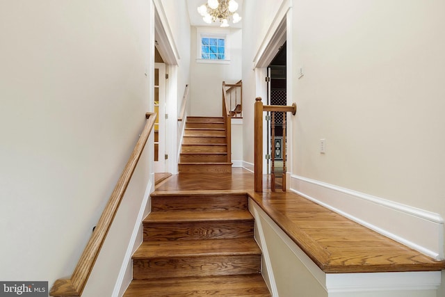 stairway featuring an inviting chandelier and hardwood / wood-style floors