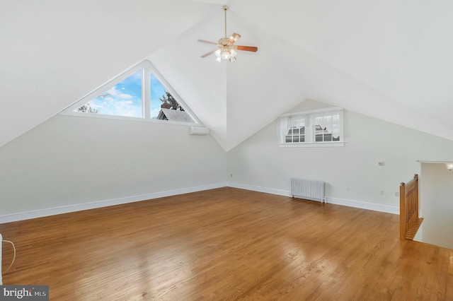 bonus room featuring hardwood / wood-style floors, lofted ceiling, radiator heating unit, and ceiling fan