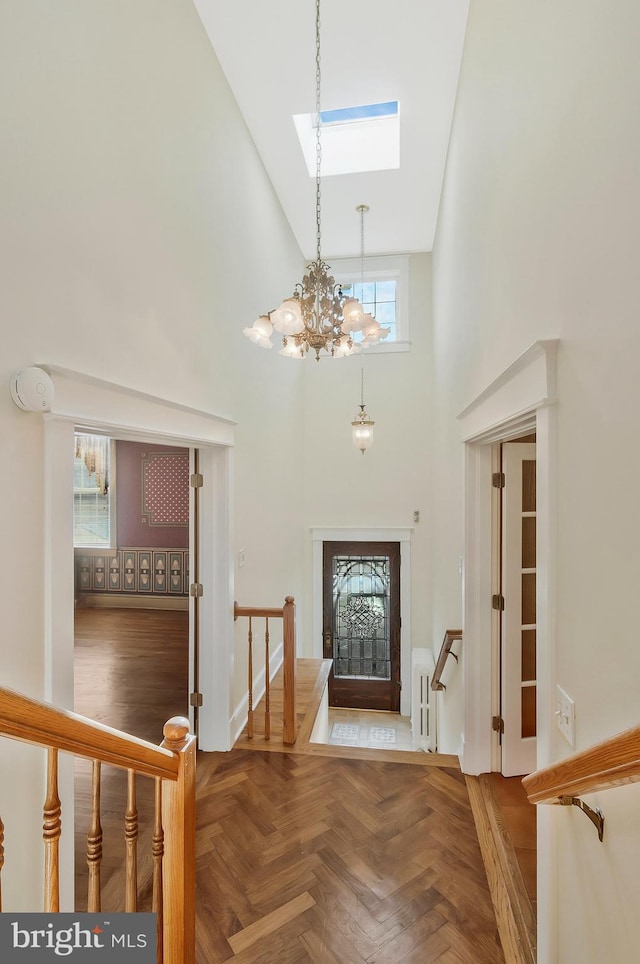 entryway featuring parquet flooring, a chandelier, and a high ceiling