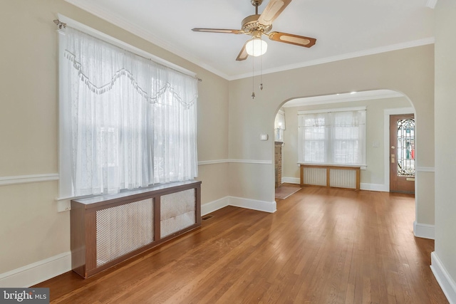 empty room with ceiling fan, wood-type flooring, and ornamental molding