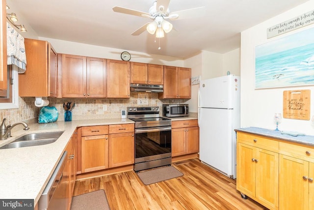 kitchen featuring decorative backsplash, light wood-type flooring, sink, and appliances with stainless steel finishes