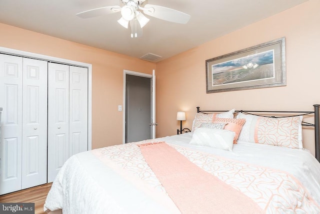 bedroom with a closet, hardwood / wood-style flooring, and ceiling fan