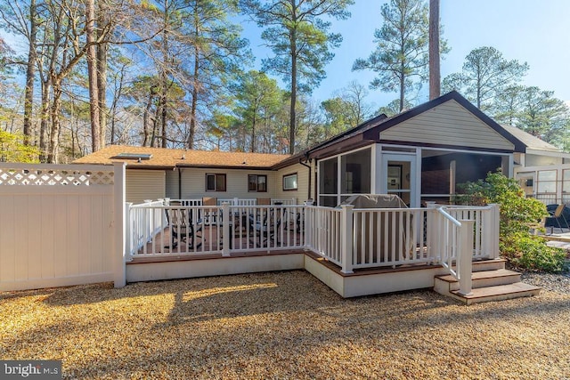 back of property with a sunroom and a deck