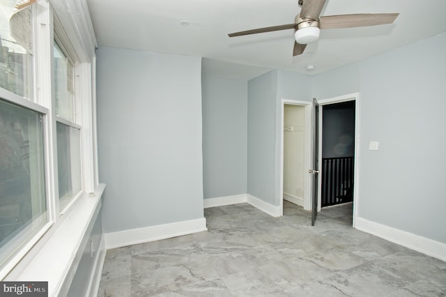 spare room with ceiling fan and plenty of natural light