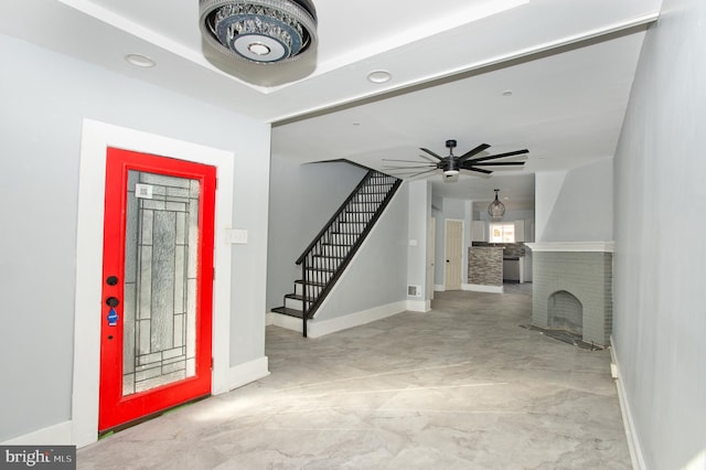 entrance foyer with ceiling fan and a brick fireplace