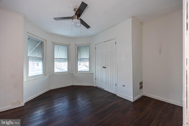 spare room with dark hardwood / wood-style flooring and ceiling fan