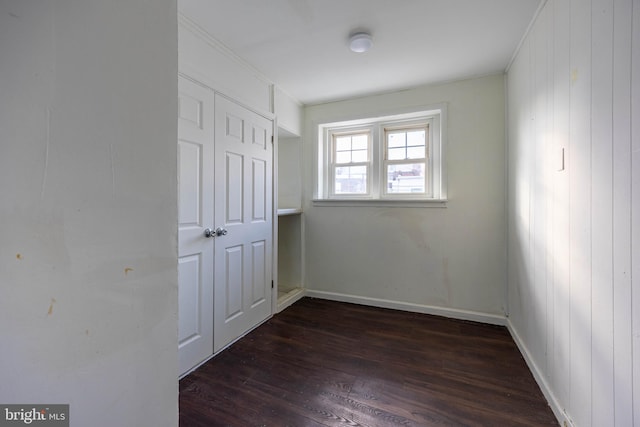 spare room with wood walls and dark hardwood / wood-style flooring