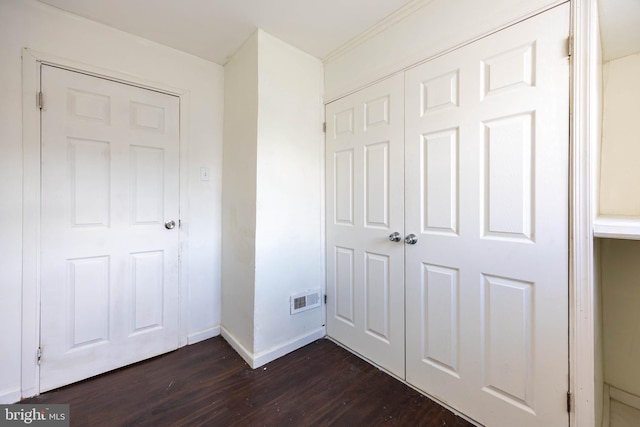 unfurnished bedroom featuring dark hardwood / wood-style flooring and a closet