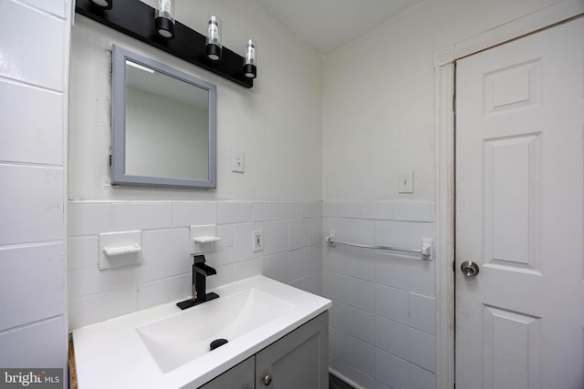 bathroom with vanity and tile walls