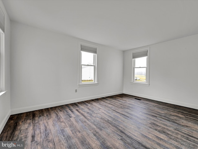 unfurnished room with dark wood-type flooring and a healthy amount of sunlight