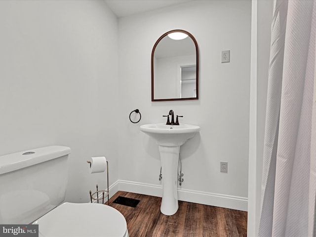 bathroom with wood-type flooring and toilet