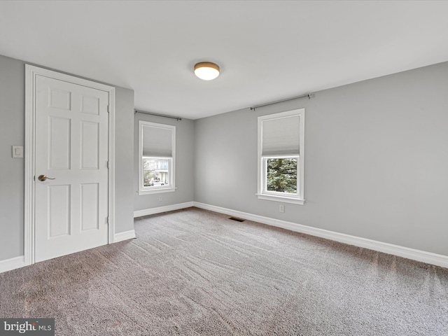 unfurnished room featuring carpet and a healthy amount of sunlight