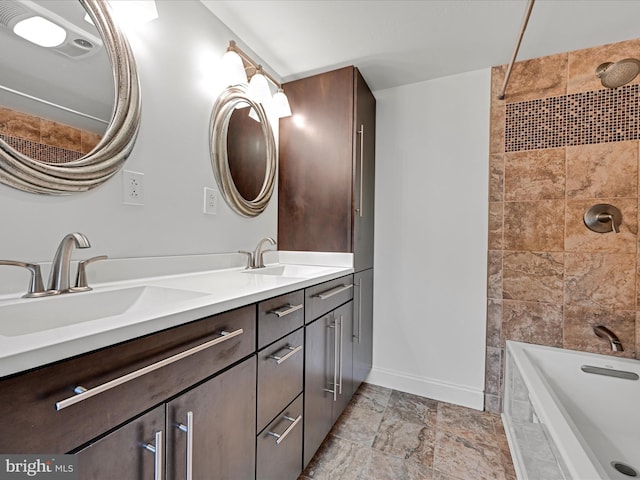 bathroom featuring vanity and tiled shower / bath