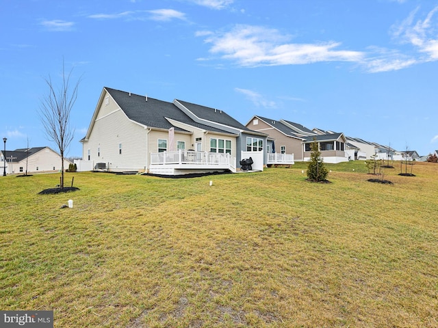 back of house with a lawn and a deck