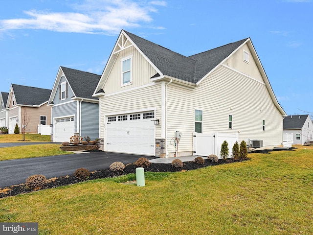 view of property exterior with a lawn, a garage, and central AC