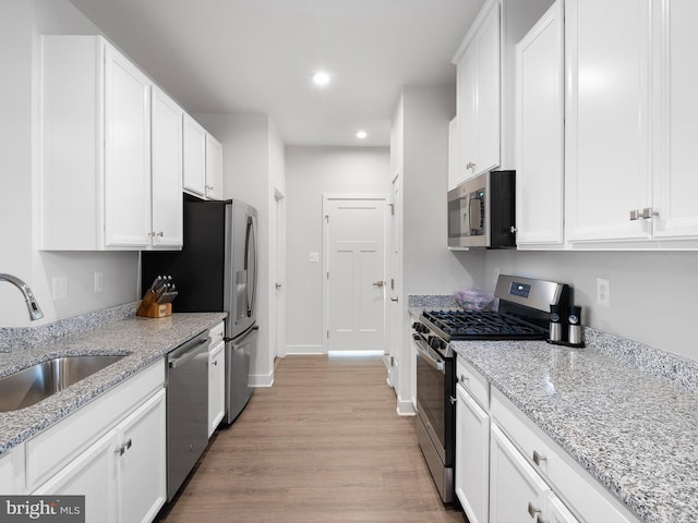 373 Guglielma Springett Dr, West Grove, PA 19390 - kitchen featuring appliances with stainless steel finishes, light wood finished floors, recessed lighting, white cabinets, and light stone countertops