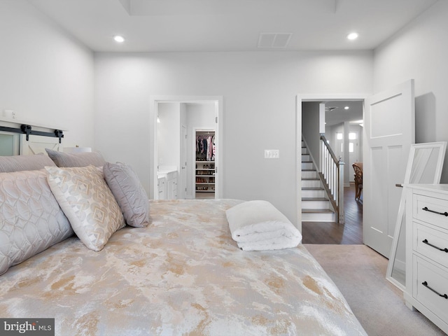 bedroom featuring light hardwood / wood-style floors, a walk in closet, and ensuite bath