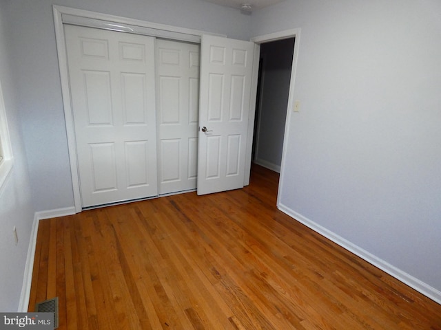 unfurnished bedroom featuring light hardwood / wood-style flooring and a closet