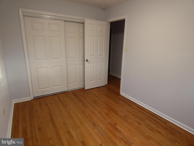 unfurnished bedroom with light wood-type flooring and a closet