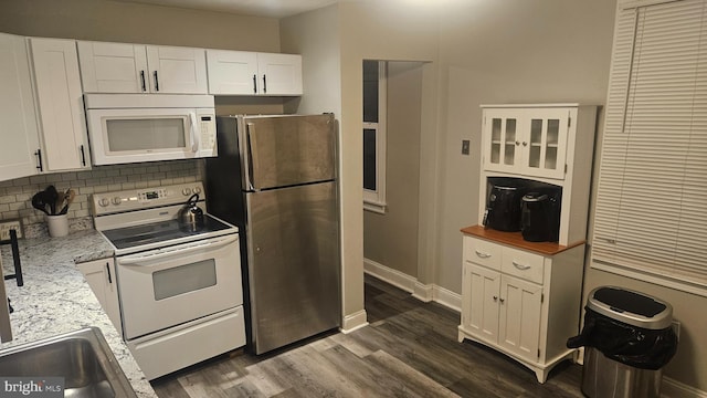 kitchen featuring backsplash, light stone counters, white appliances, dark wood-type flooring, and white cabinets