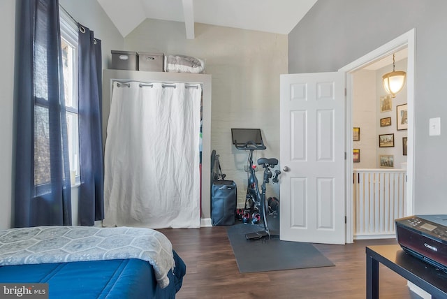 bedroom with lofted ceiling with beams and dark wood-type flooring