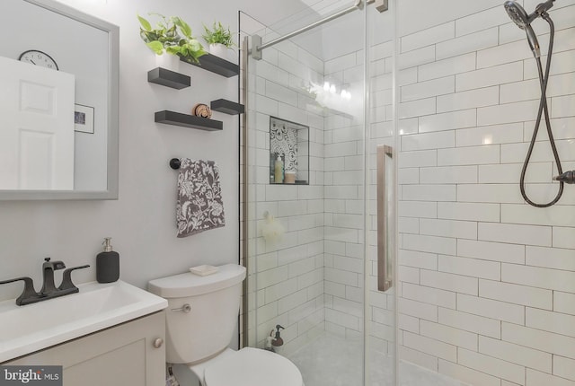 bathroom with vanity, toilet, and a shower with door