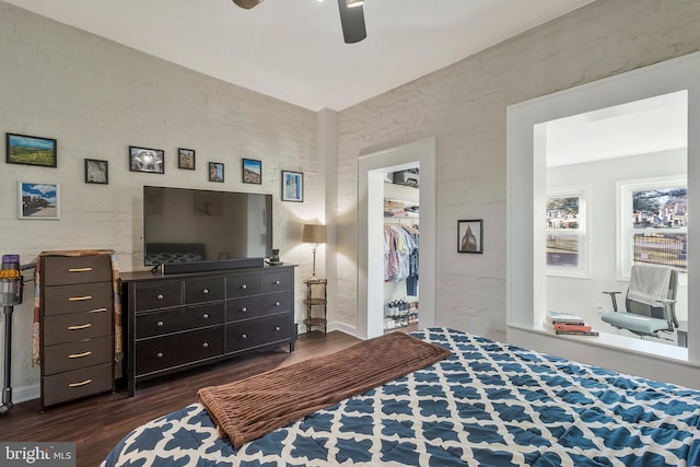 bedroom with a closet, dark hardwood / wood-style floors, vaulted ceiling, and ceiling fan